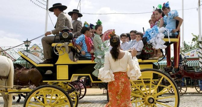 Grupo de niños montado en un coche de caballos en la Feria de Abril / EFE