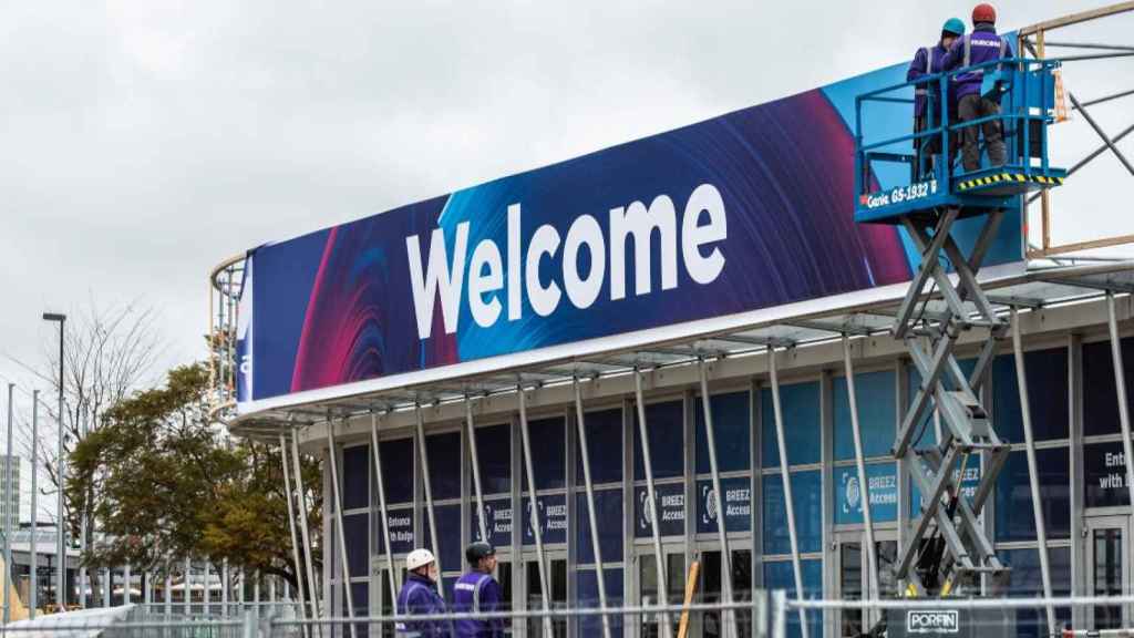 Trabajadores colocan un cartel de 'Welcome' en la entrada principal del Mobile World Congress, organizado por GSMA / EUROPA PRESS