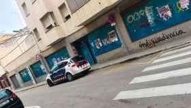 Imagen de un coche de Mossos d'Esquadra ante un local vacío para evitar su okupación / CG