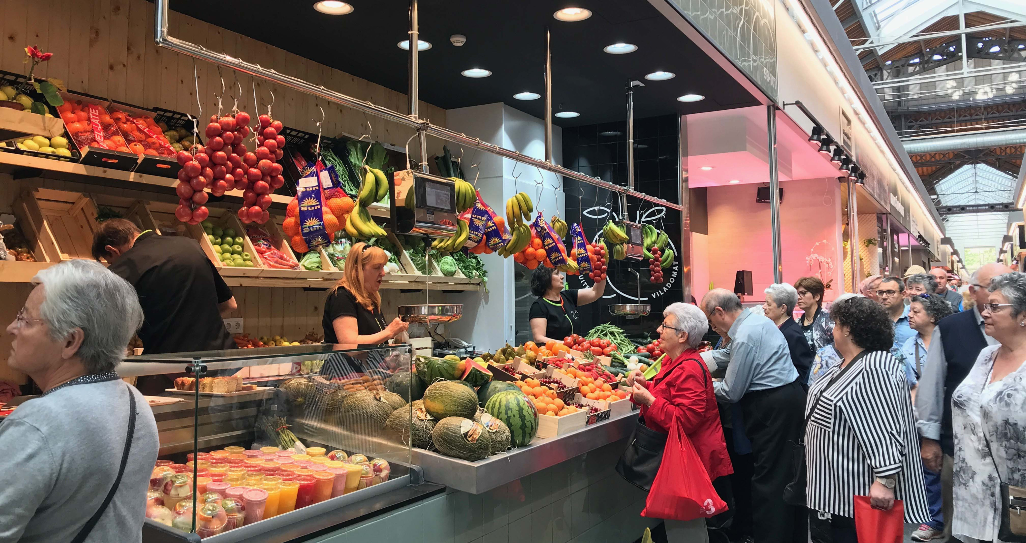 Clientes en un puesto de frutas y verduras en el Mercat de Sant Antoni / CG