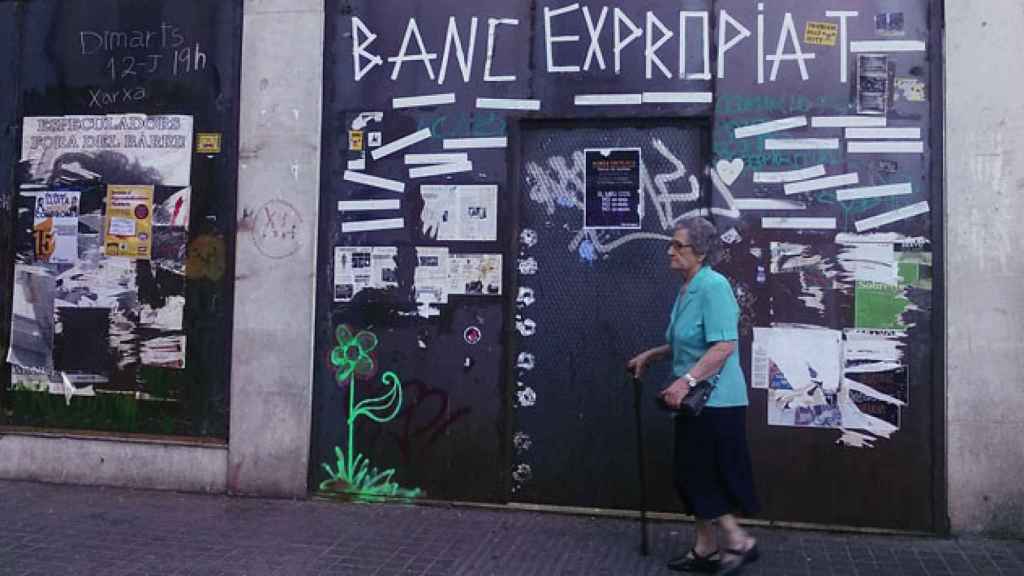 Una mujer camina frente a la puerta del Banco Expropiado / CG