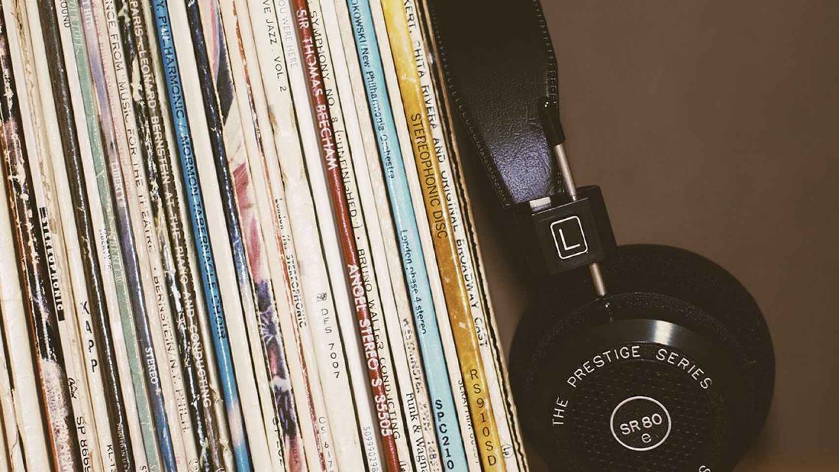 Auriculares junto a una colección de discos nacionales imprescindibles / UNSPLASH