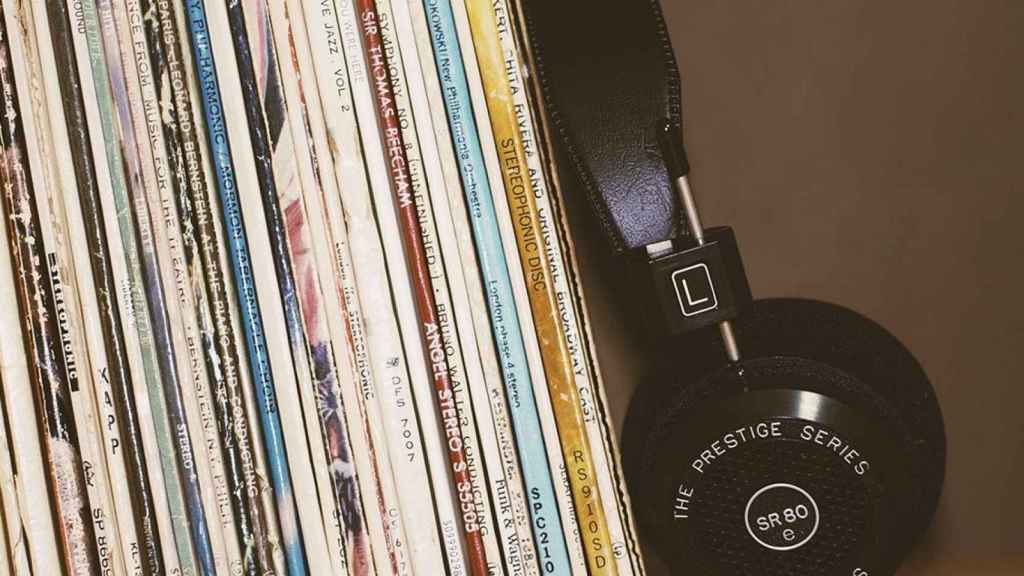 Auriculares junto a una colección de discos nacionales imprescindibles / UNSPLASH