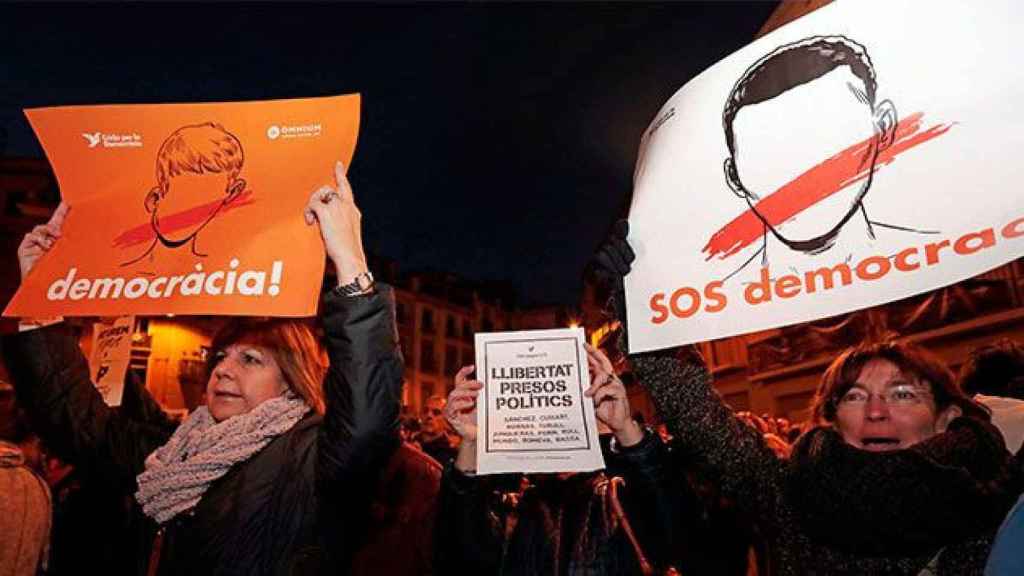 Manifestantes sostienen carteles de Òmnium Cultural en la manifestación del miércoles para la libertad de los presos políticos / EFE