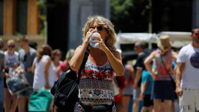 Una mujer bebe agua en plena ola de calor en Cataluña / EFE