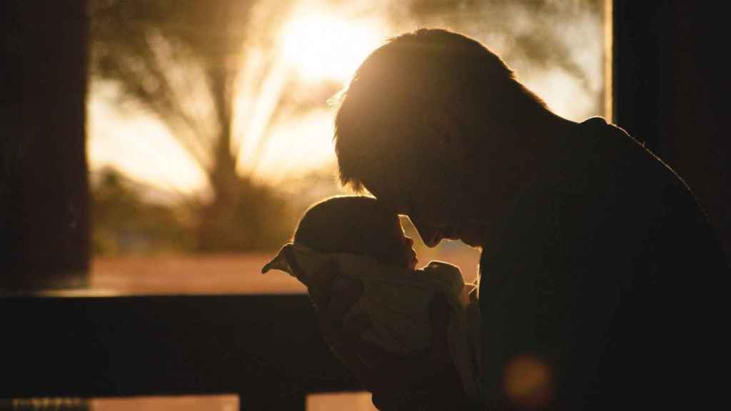 Un padre sujeta a su bebé recién nacido / CG