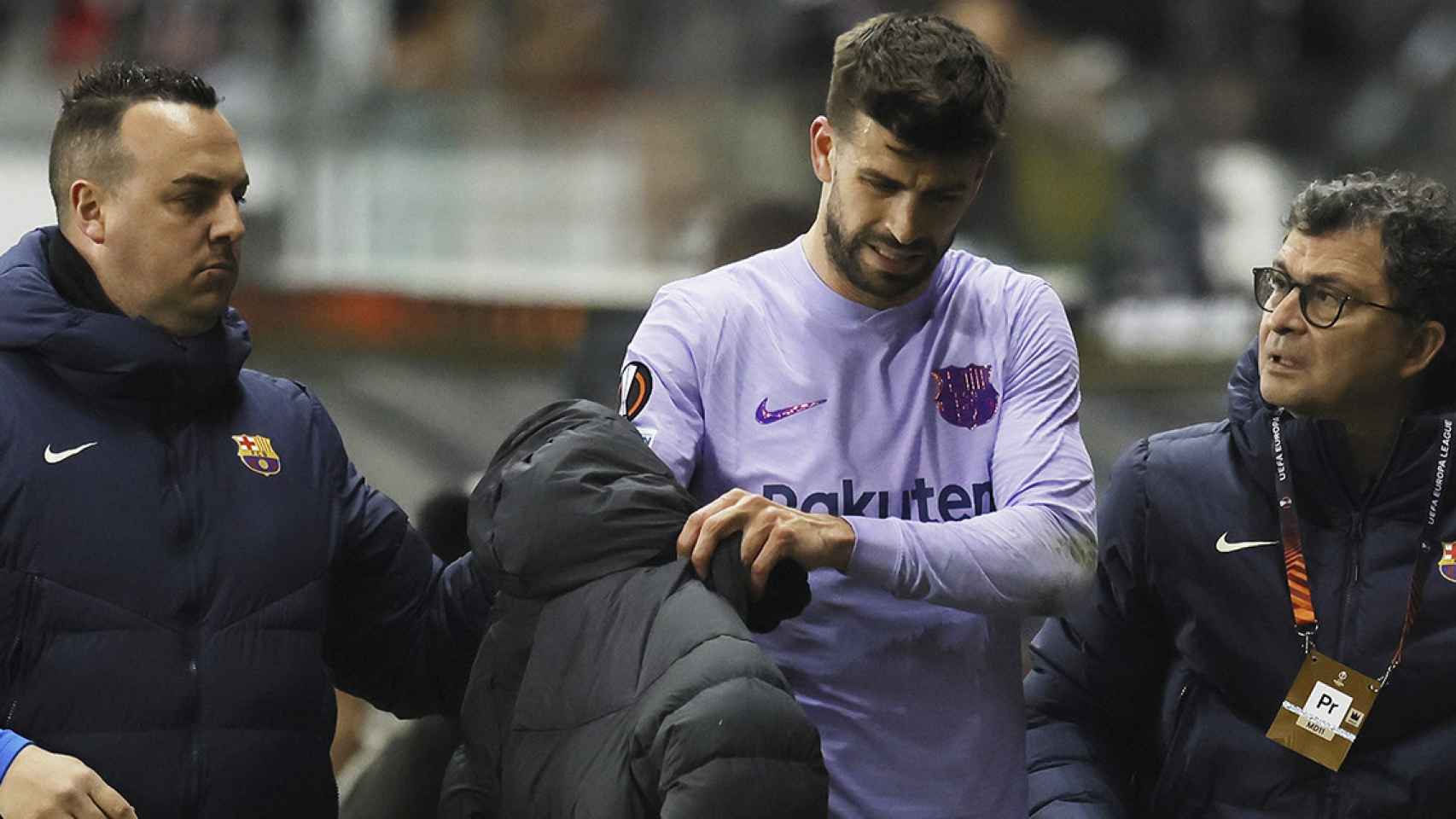 Gerard Piqué, saliendo en compañía de los servicios médicos del Barça, tras sufrir una lesión en Frankfurt / EFE