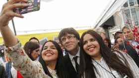 El presidente de la Generalitat Carles Puigdemont se hace un 'selfie' con dos gemelas / EFE