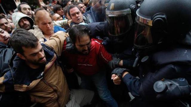 Agentes antidisturbios de la Policía Nacional forman un cordón de seguridad frente al colegio Ramón Llull de Barcelona / EFE