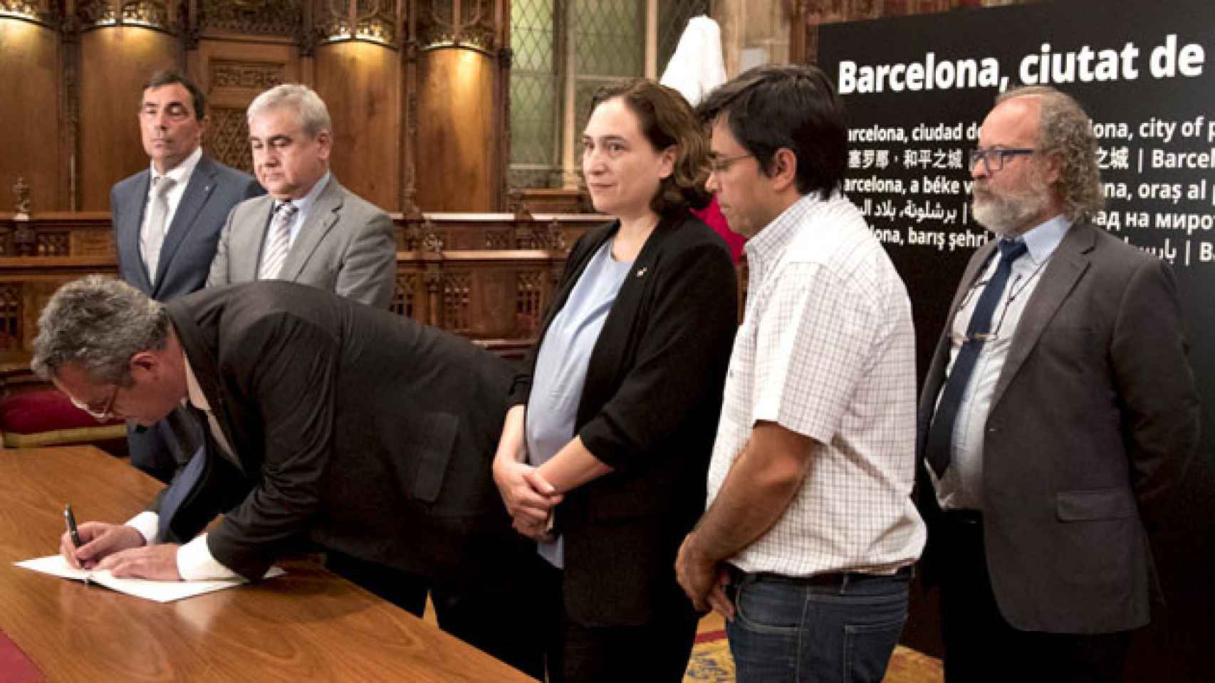 Ada Colau (c), alcaldesa de Barcelona, asiste a la firma del libro de condolencias del 'conseller' de Interior, Joaquim Forn (2i), junto a Gerardo Pisarello (2d), primer teniente de alcalde / EFE