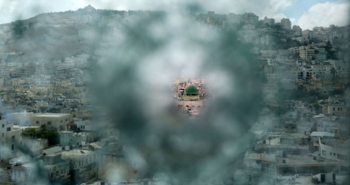 Una mezquita de Cisjordania vista a través de un impacto de bala en un cristal / Shadi Jarar'ah – EUROPA PRESS