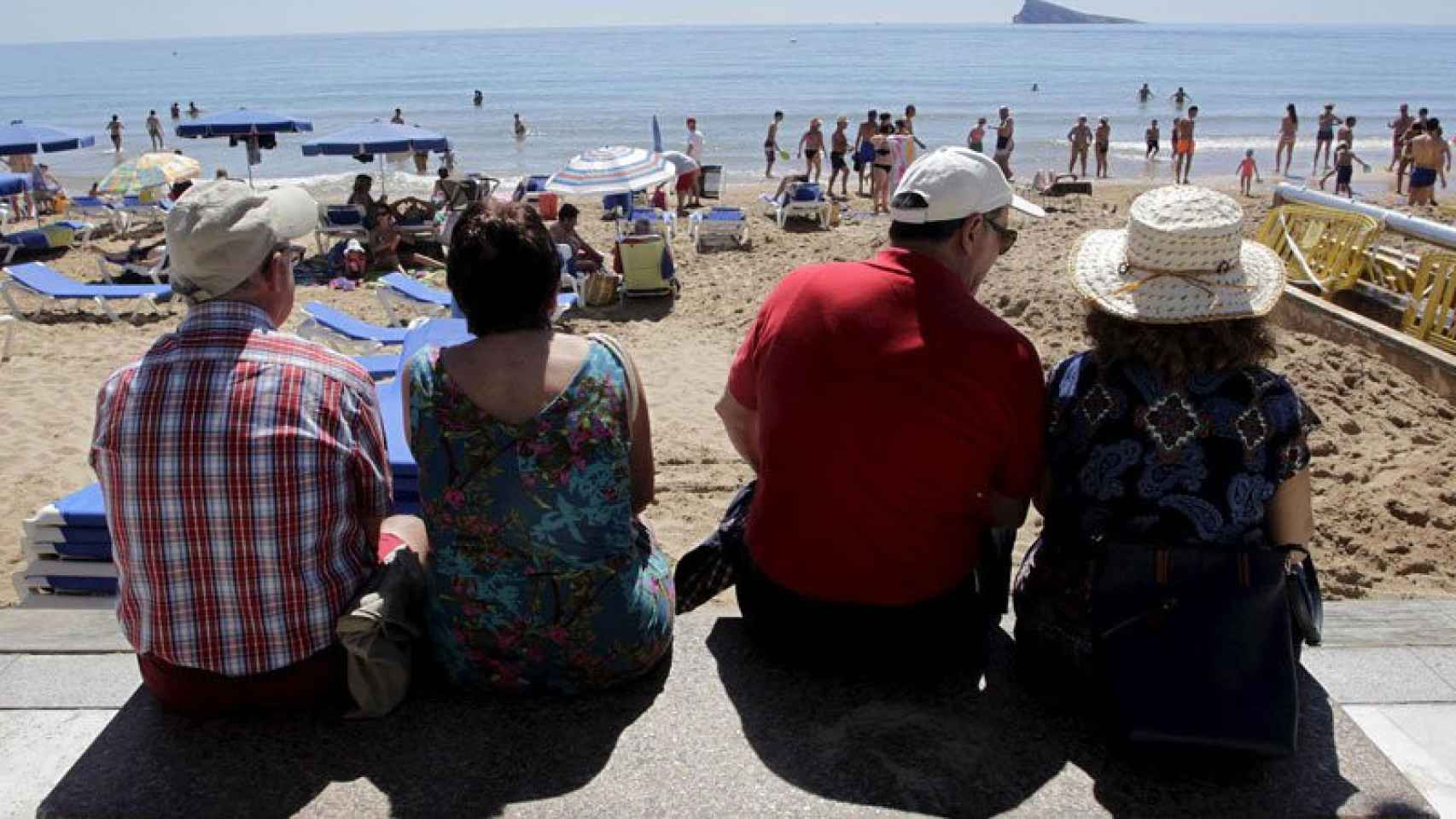 Dos parejas de viajeros mayores contemplan la playa de Benidorm, en un viaje de la Imserso / CG