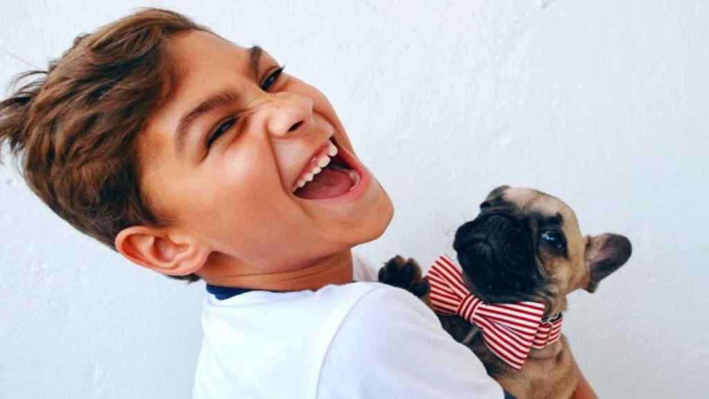 Un niño jugando feliz con su nuevo perro / Alicia Jones en UNSPLASH