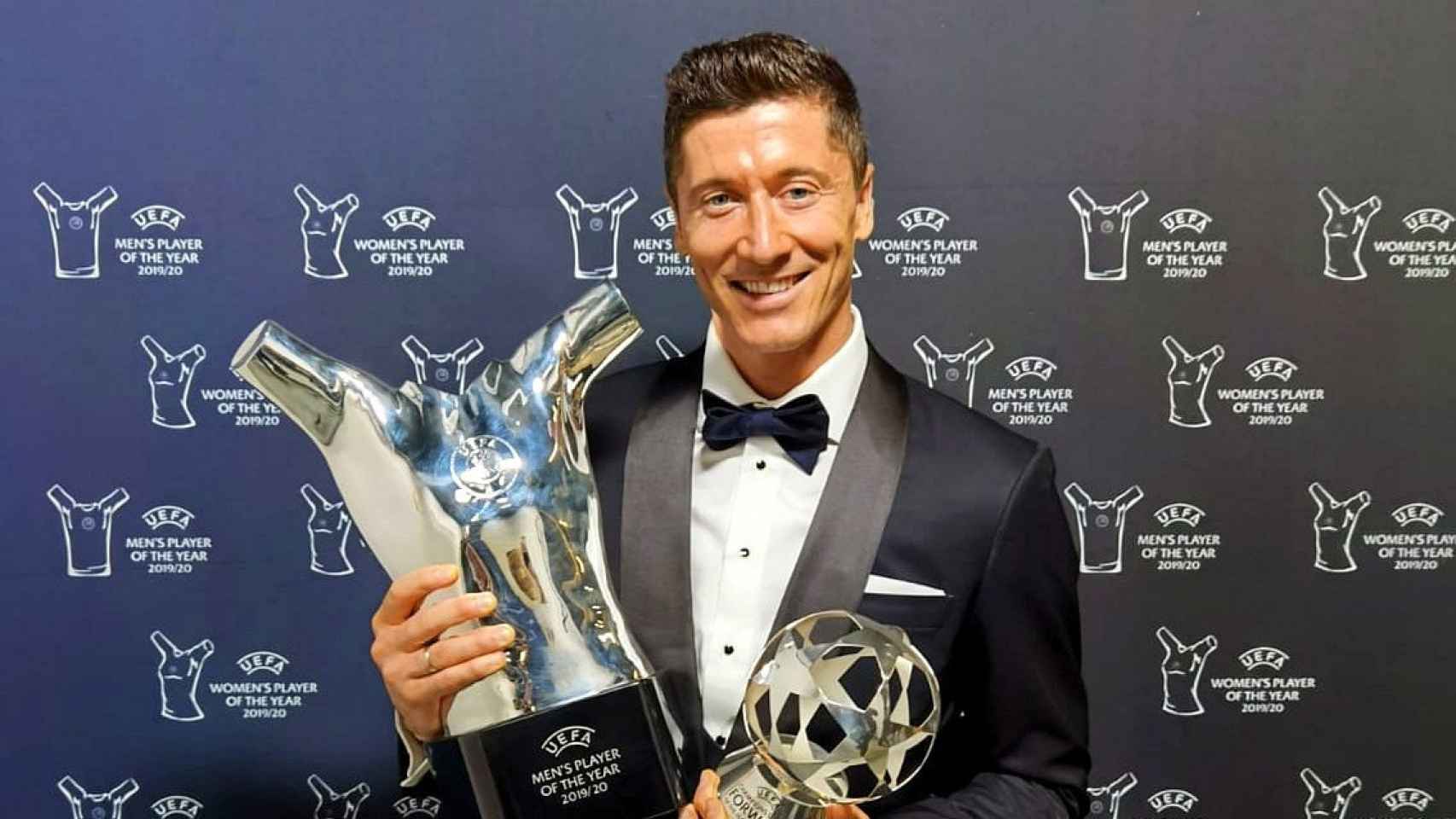 Robert Lewandowski, de traje, recibiendo dos premios de la UEFA en 2020 / Bayern