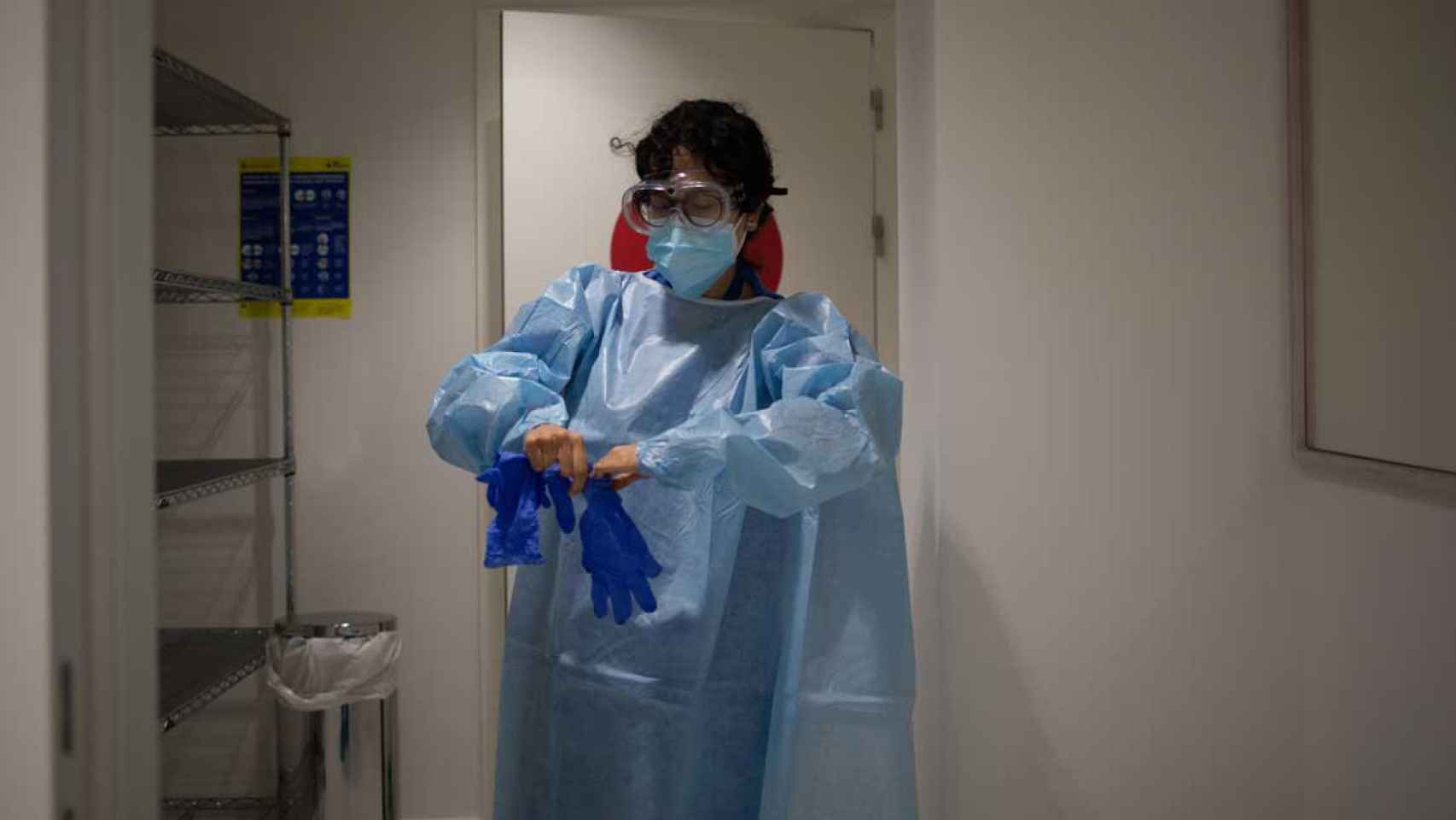 Una profesional sanitaria se viste con un Equipo de Protección Individual (EPI) en el hospital Vall d'Hebron para atender a pacientes hospitalizados por Covid / EUROPA PRESS