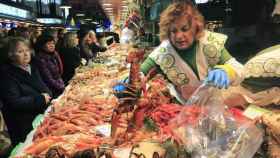 Una pescatera coge un centollo en un mercado de Valencia antes de Navidad / EFE