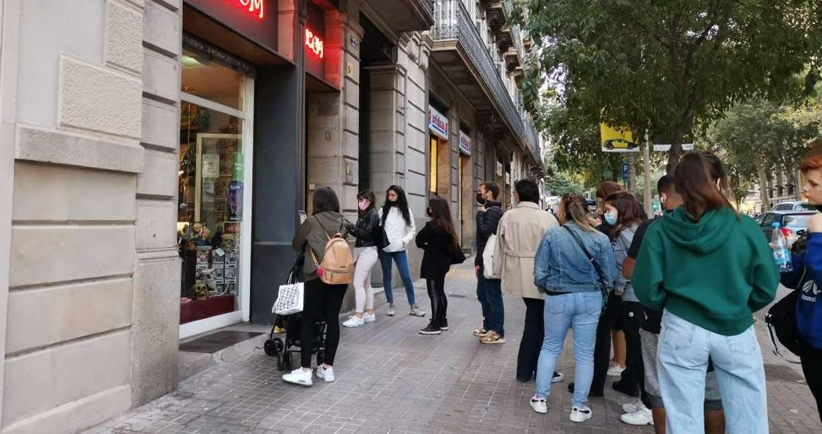 Jóvenes a las puertas de una tienda de disfraces en el centro de Barcelona / CG