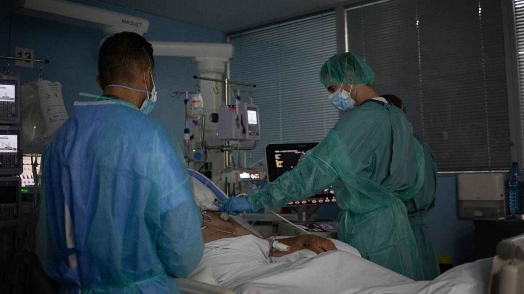 Hospitales. Personal sanitario visita a un paciente Covid ingresado en la uci del Hospital de la Santa Creu i Sant Pau de Barcelona / David Zorrakino (EP)