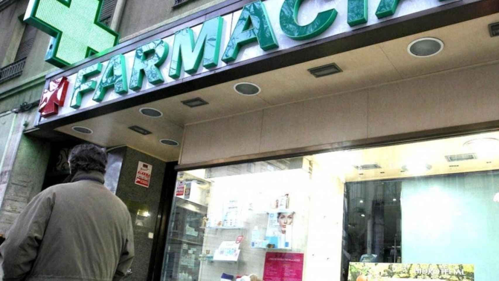 Un ciudadano pasa frente a una farmacia / EFE