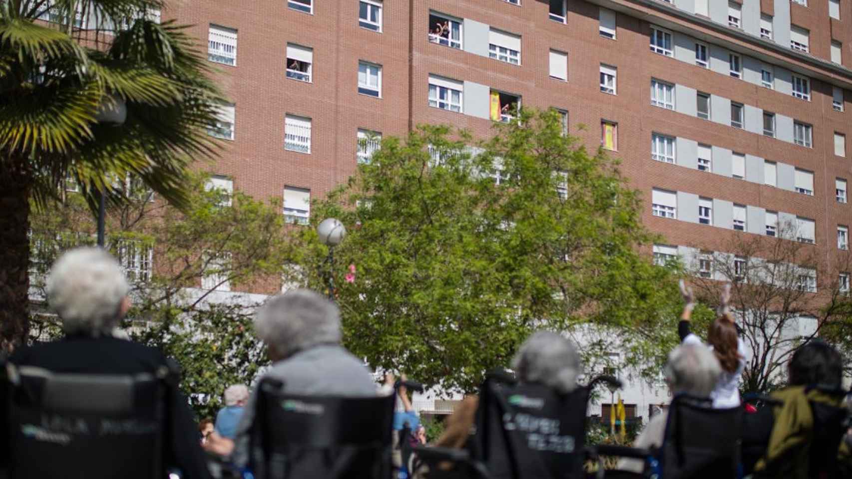 Vecinos del barrio saludan desde sus ventanas a los ancianos de una residencia de mayores / EP