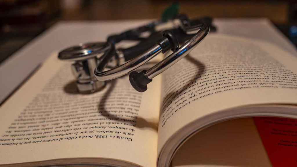 El estetoscopio de un médico sobre un libro / CG