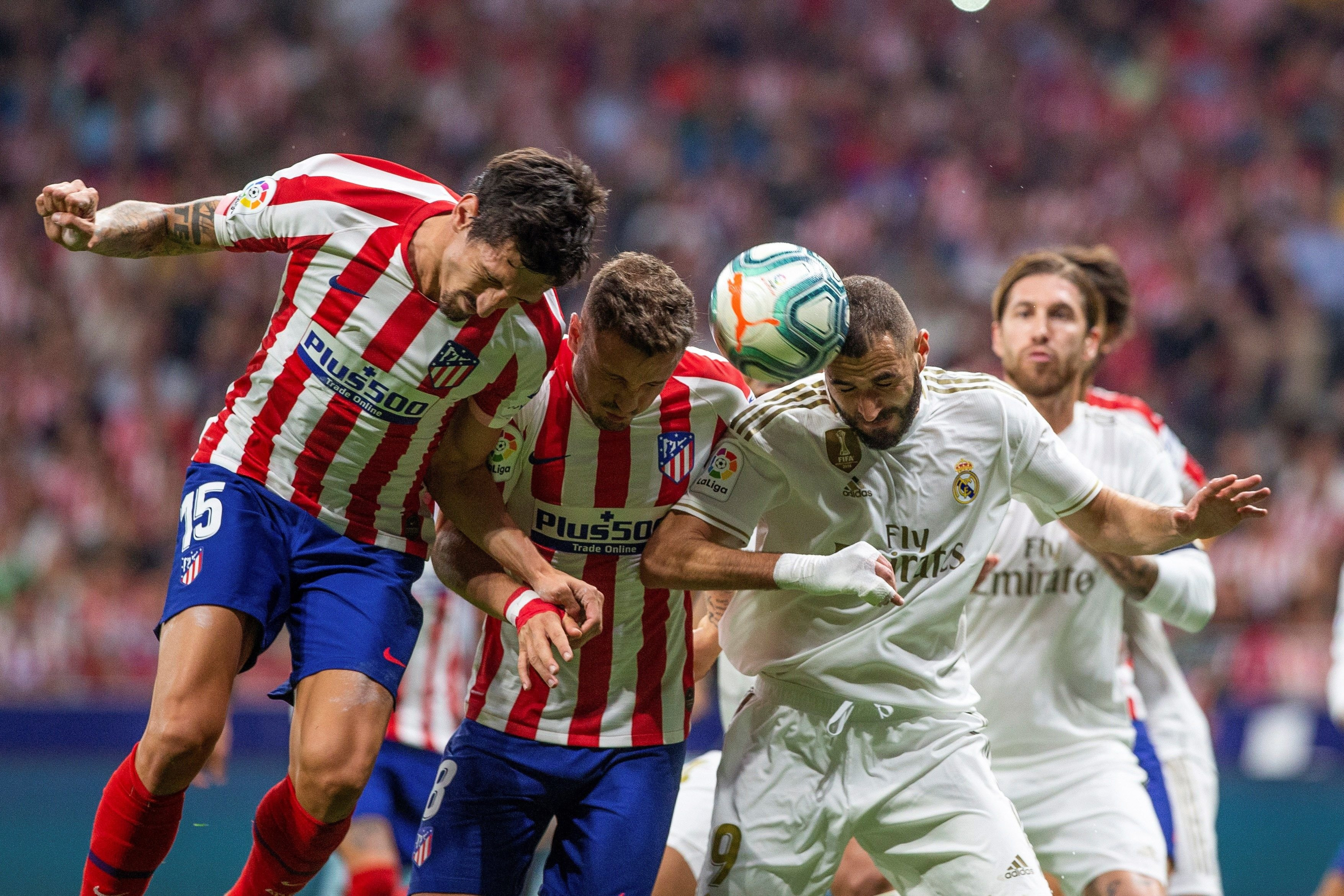 Jugadores de Atlético y Real Madrid luchando un balón aéreo / EFE