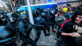 Los Mossos d'Esquadra cargan contra los manifestantes ante la Delegación del Gobierno en Cataluña, con un furgón con una pintada de cómplices al fondo / EFE