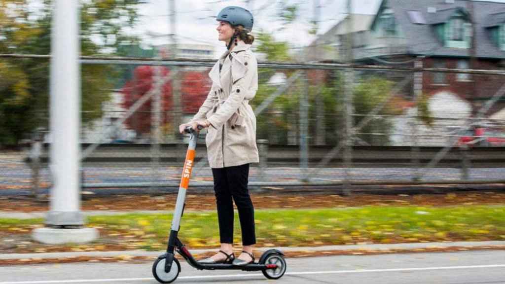 Una chica pasea por una ciudad en patinete, en el que a partir de abril Barcelona obliga al uso del casco  / FORD