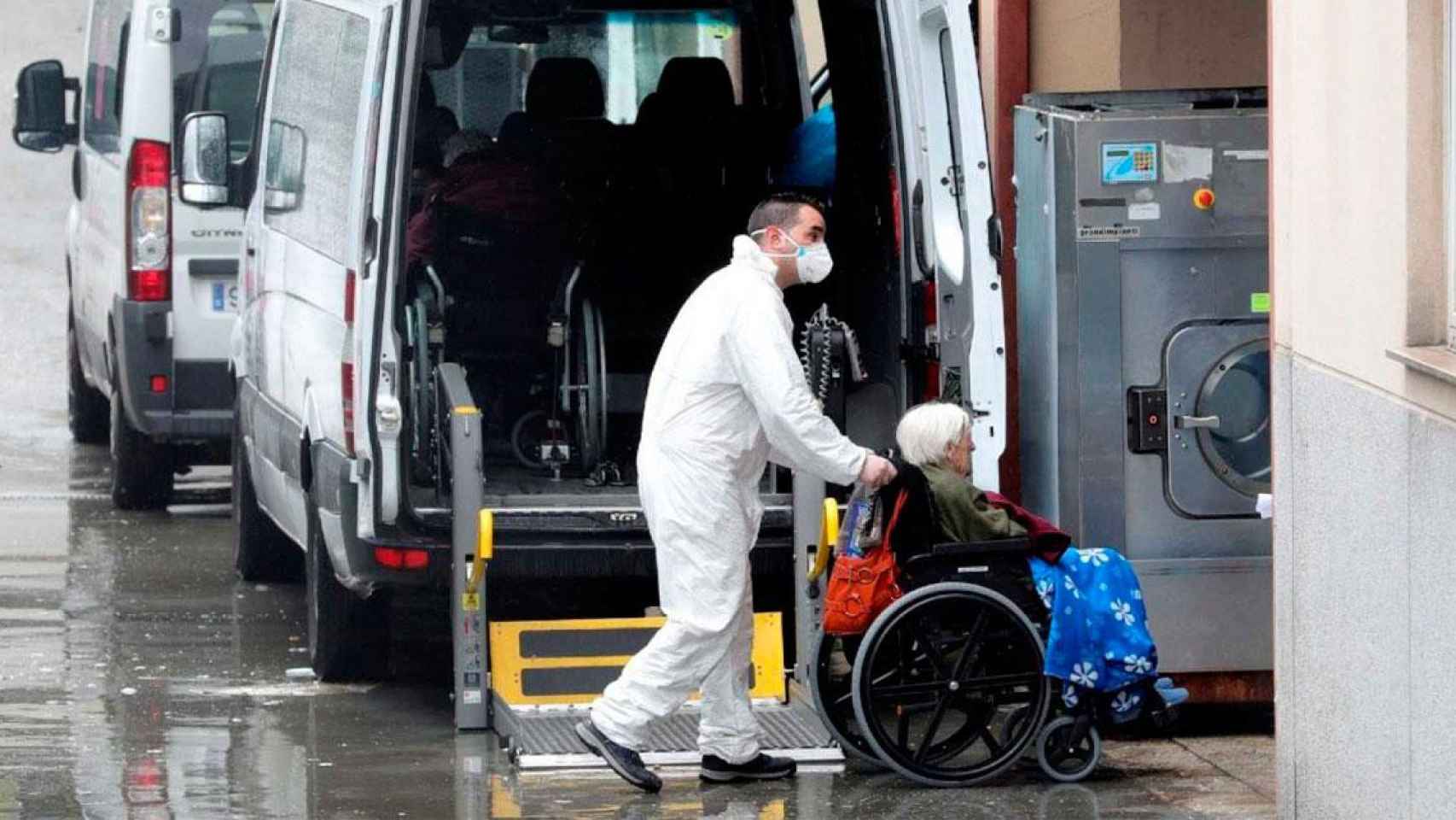 Un sanitario traslada a una anciana de una residencia / EFE