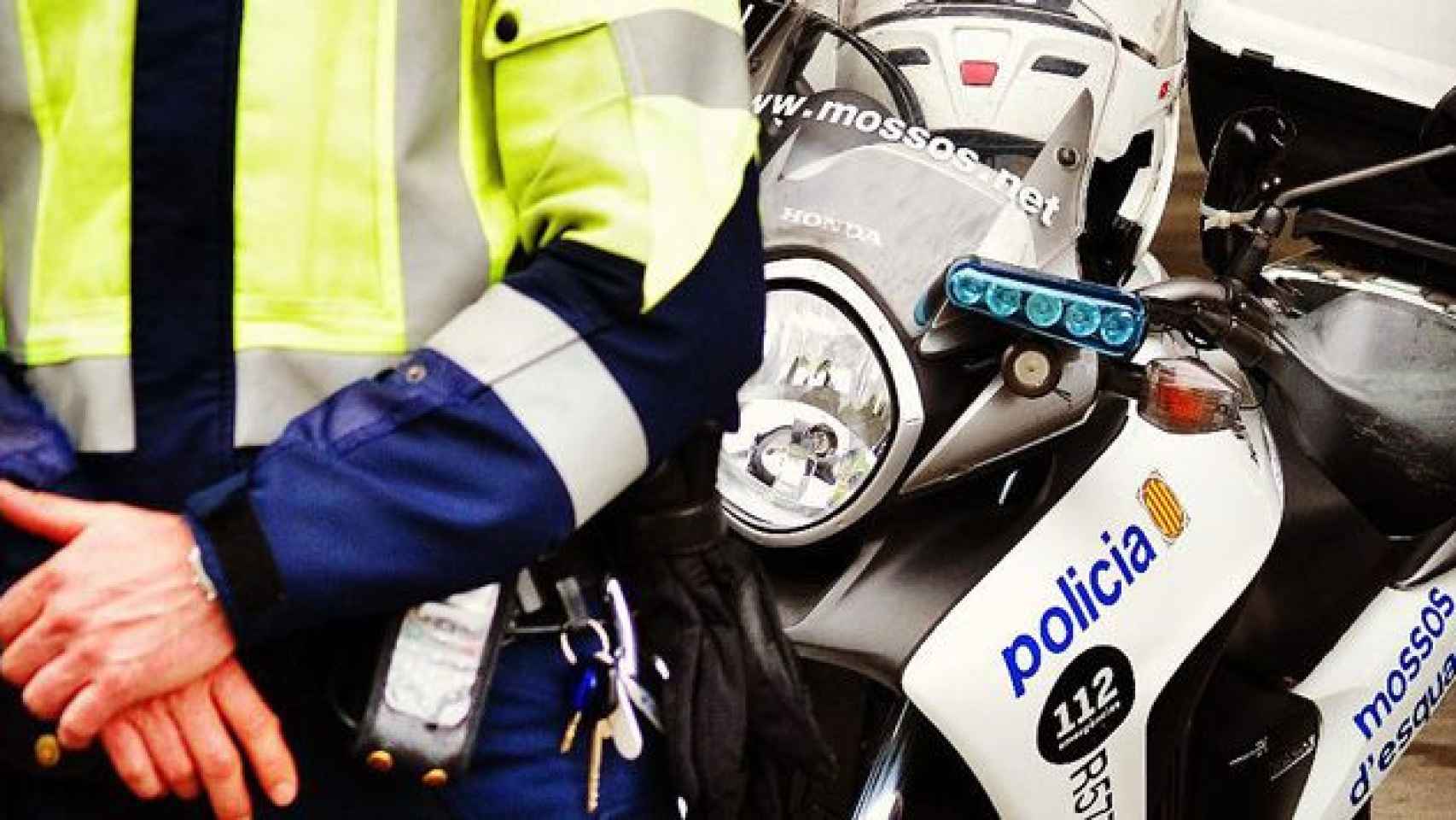 Un agente de los Mossos d'Esquadra junto a una moto de la policía catalana / CG