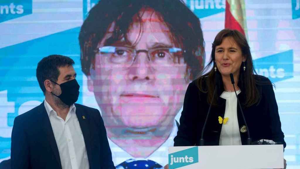 Laura Borràs, acompañada por el secretario general de JxCat, Jordi Sánchez, con Carles Puigdemont de fondo / EFE