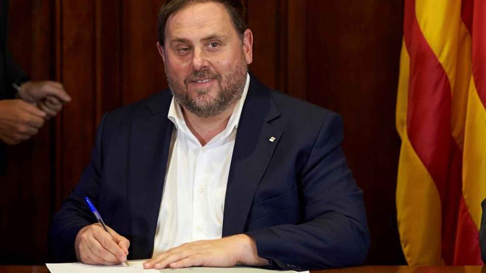 El vicepresidente de la Generalitat, Oriol Junqueras, firma la convocatoria del referéndum / EFE