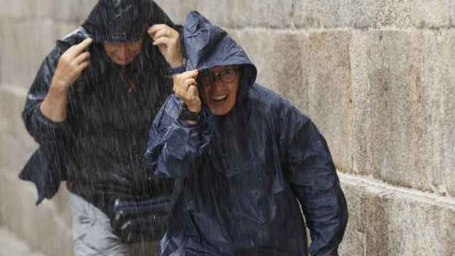 Turistas y peregrinos corren para resguardarse de la lluvia, este martes en Santiago de Compostela, Galicia / EFE