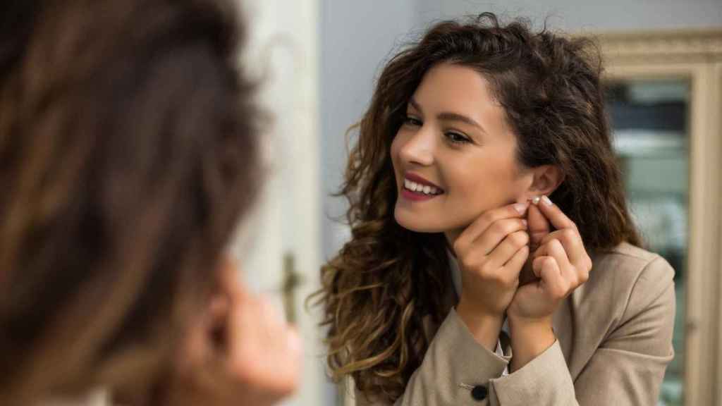 Mujer poniéndose unos pendientes