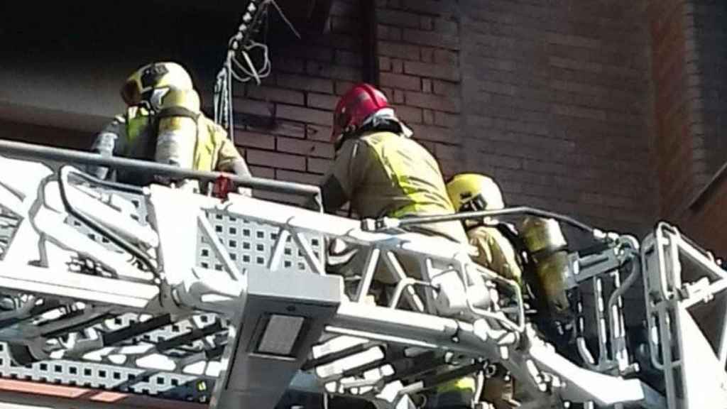 Bomberos durante la extinción del incendio en un bloque de pisos en Santa Coloma donde ha fallecido una mujer / BOMBERS