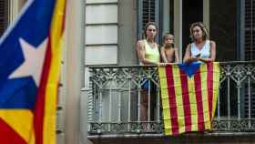 Una familia observa las movilizaciones de la Diada desde su balcón / MIGUEL OSÉS