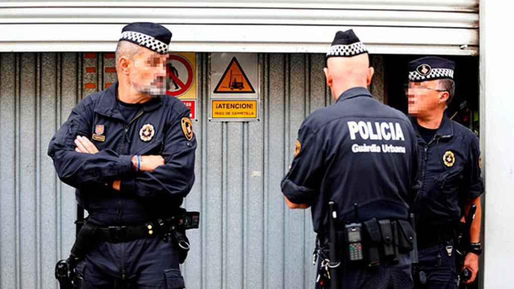 Agentes de la Guardia Urbana de Barcelona custodian las urnas municipales en un local de la calle Perú / EFE