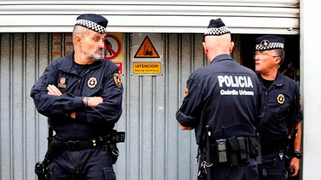 Agentes de la Guardia Urbana de Barcelona custodian las urnas municipales en un local de la calle Perú / EFE