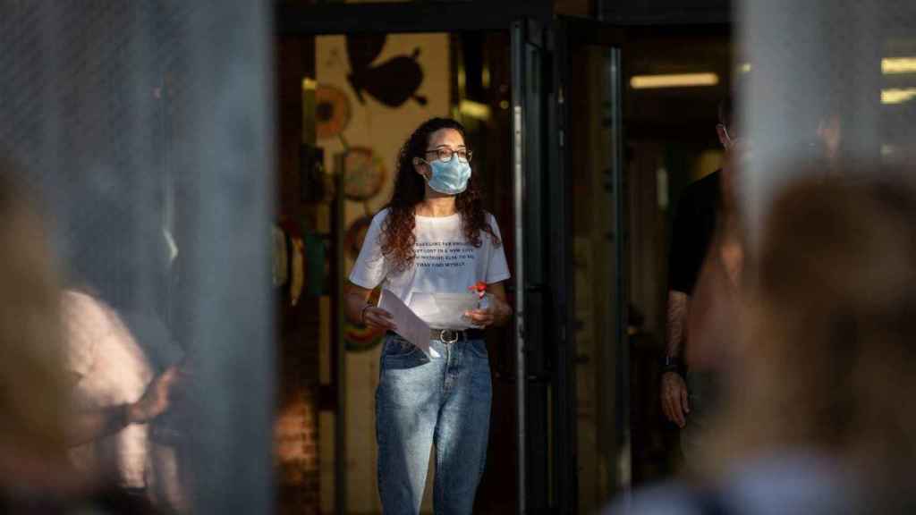 Una profesora a la puerta de un colegio con mascarilla para protegerse del Covid / EP