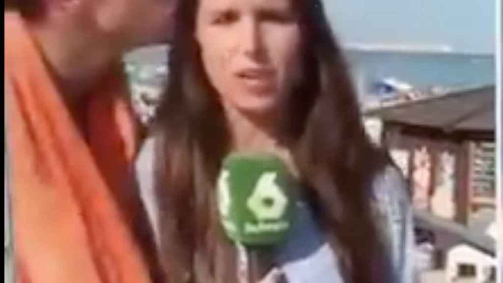 Una foto del momento en que un individuo besa a la reportera Elizabeth López