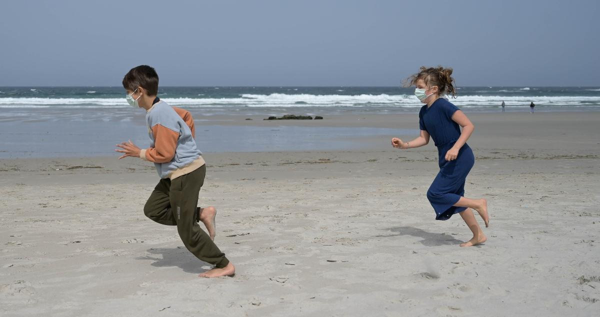 Niños jugando en una playa / EP