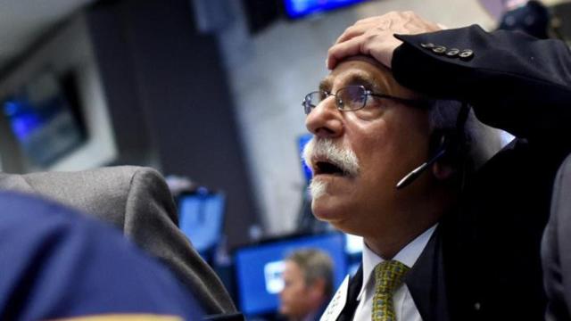 Un operador de Wall Street se lleva las manos a la cabeza durante el desplome de la apertura de la bolsa de Nueva York.