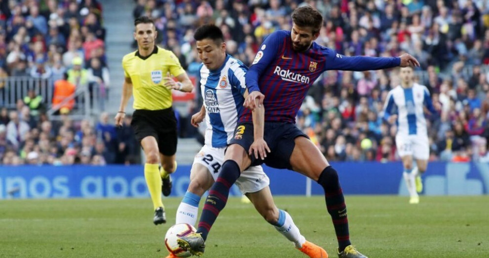 Wui Lei luchando un balón con Gerard Piqué en un derbi / Redes