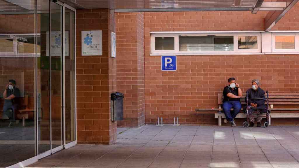 Dos personas a la entrada del hospital de Igualada / EFE