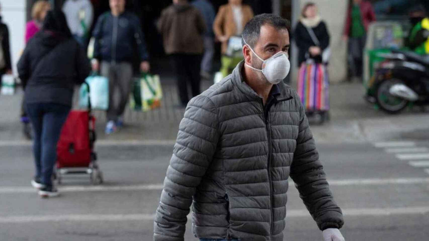 Un hombre pasea con una de las mascarillas que serán obligatorias / EFE