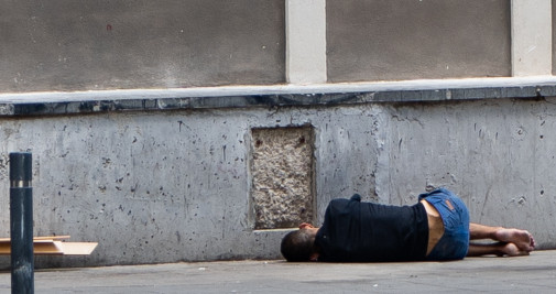 Un hombre en el suelo de una calle del Raval, donde ha regresado con fuerza la heroína / LUIS MIGUEL AÑÓN (CG)
