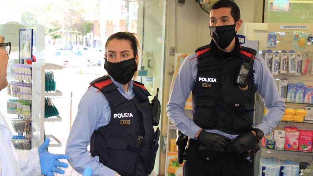 Una pareja Mossos d'Esquadra con mascarillas en una farmacia / TWITTER MOSSOS