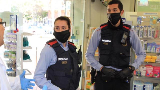 Una pareja Mossos d'Esquadra con mascarillas en una farmacia / TWITTER MOSSOS