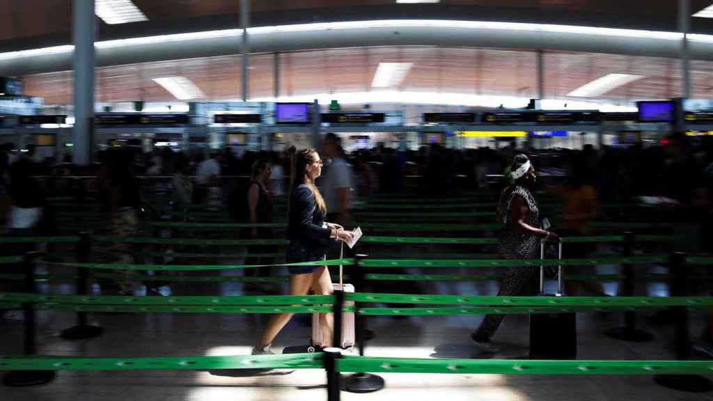 Dos personas en el control de seguridad del aeropuerto de El Prat / EFE