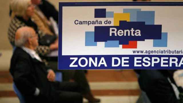 Varios contribuyentes esperan su turno en la cita previa de la campaña de la Renta / EFE